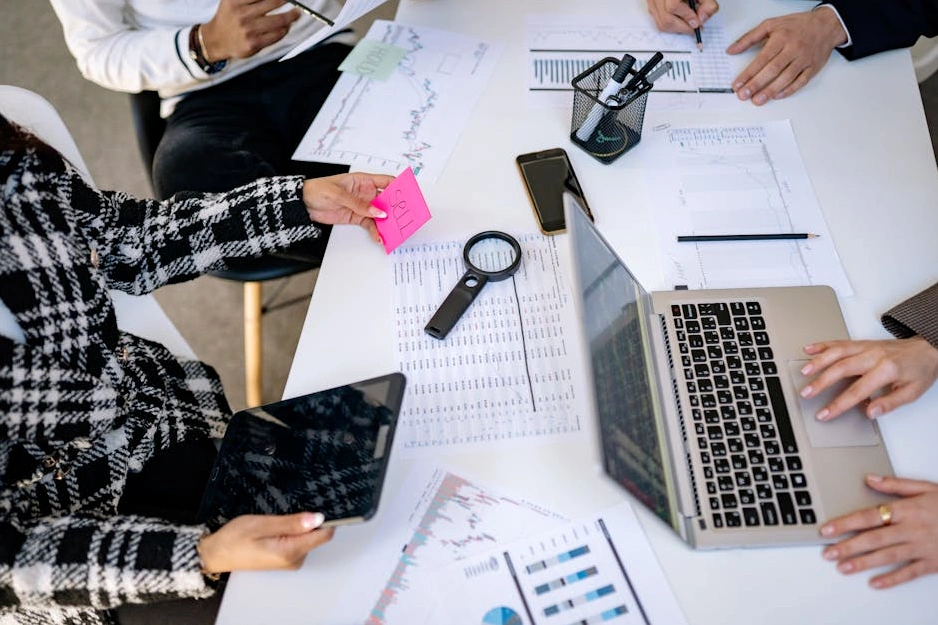 Dizüstü bilgisayarıyla gülümseyen ve finansal grafiklere bakan bir kişi